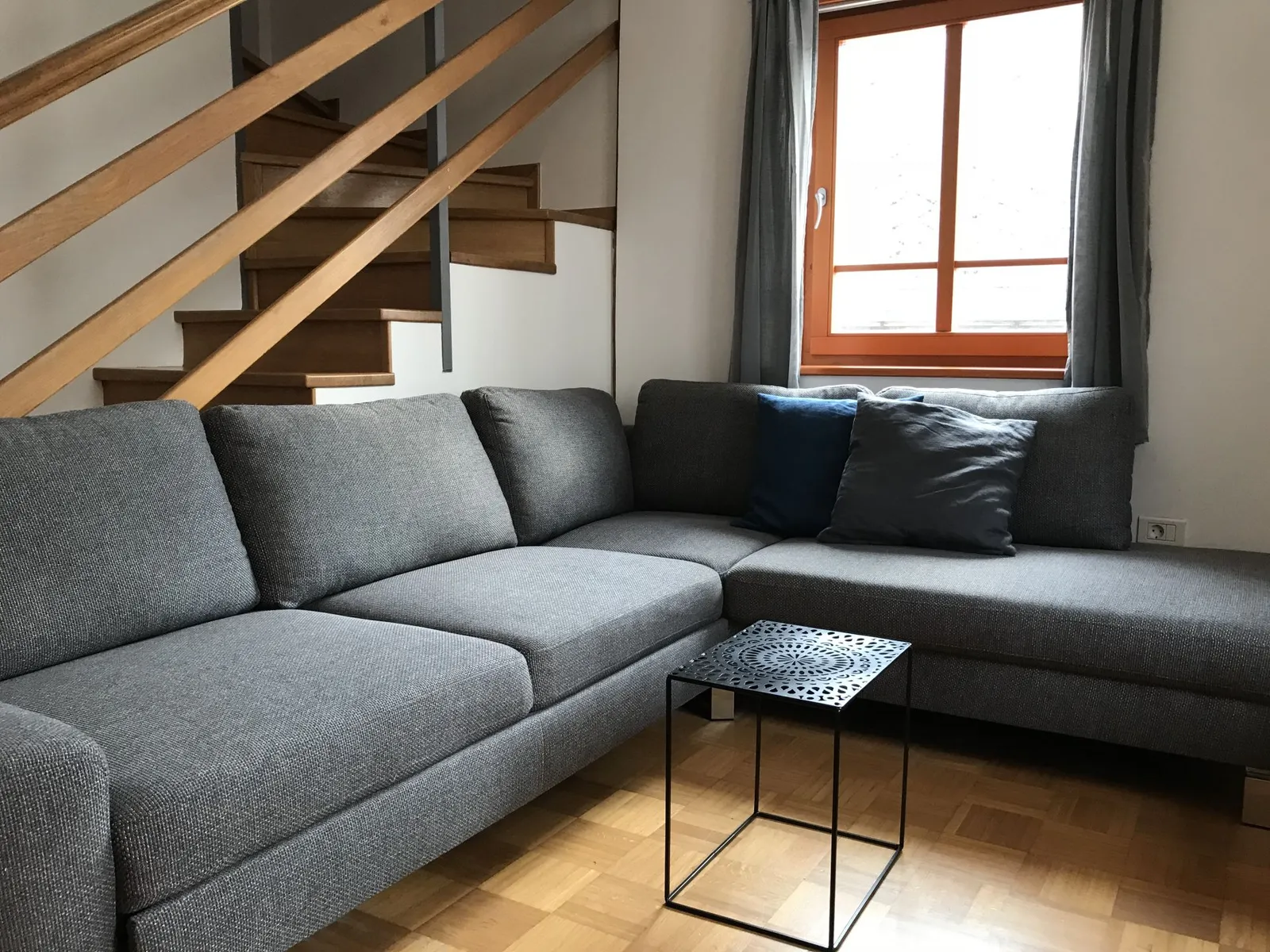 Apartma 11: kotni kavč pod stopnicami