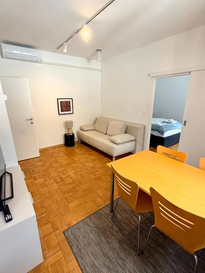 Apartma 7: dnevni prostor s kavčem in vrata v spalnico