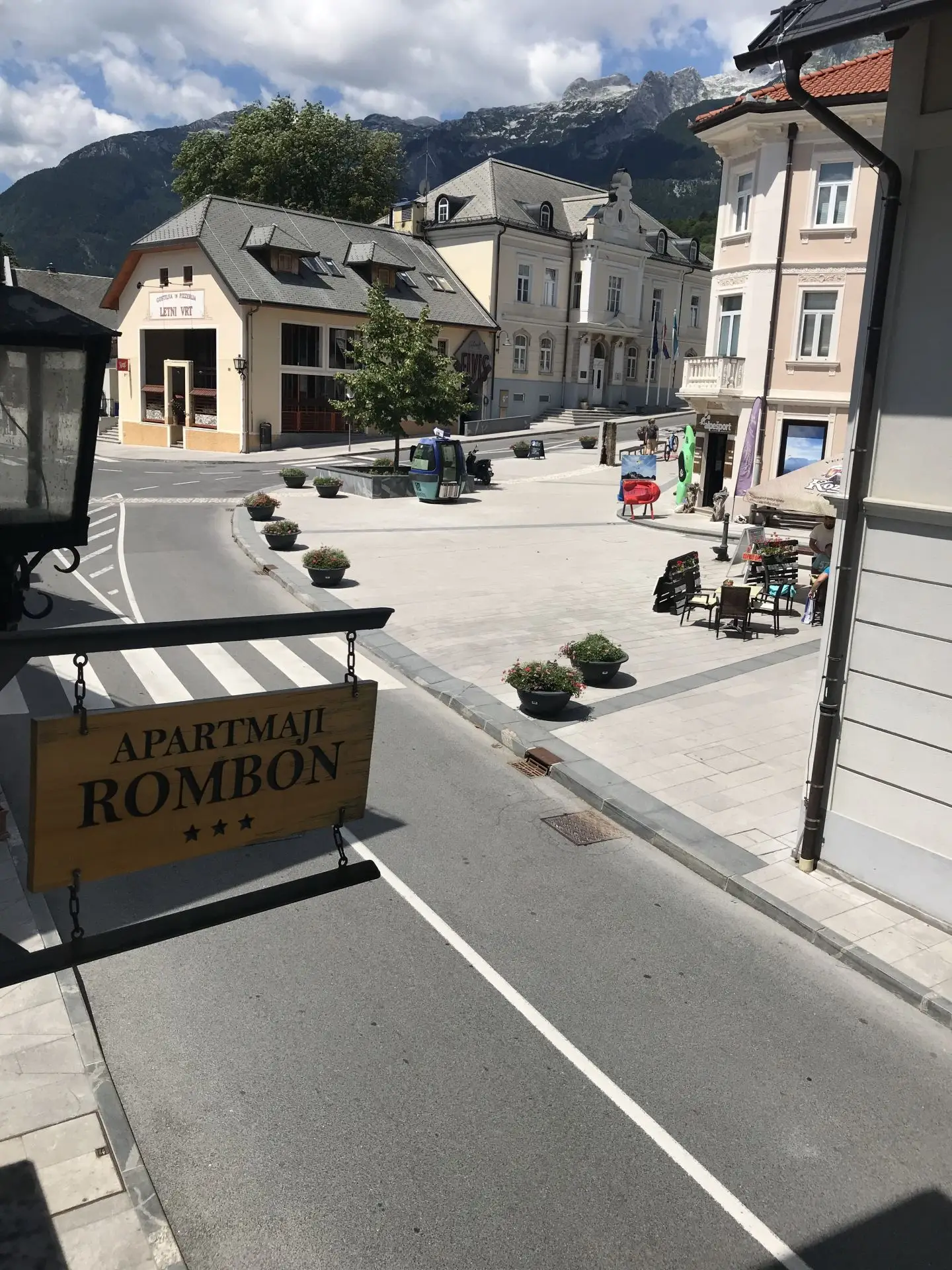 Pogled z našega okna na trg in viseči napis Apartmaji Rombon